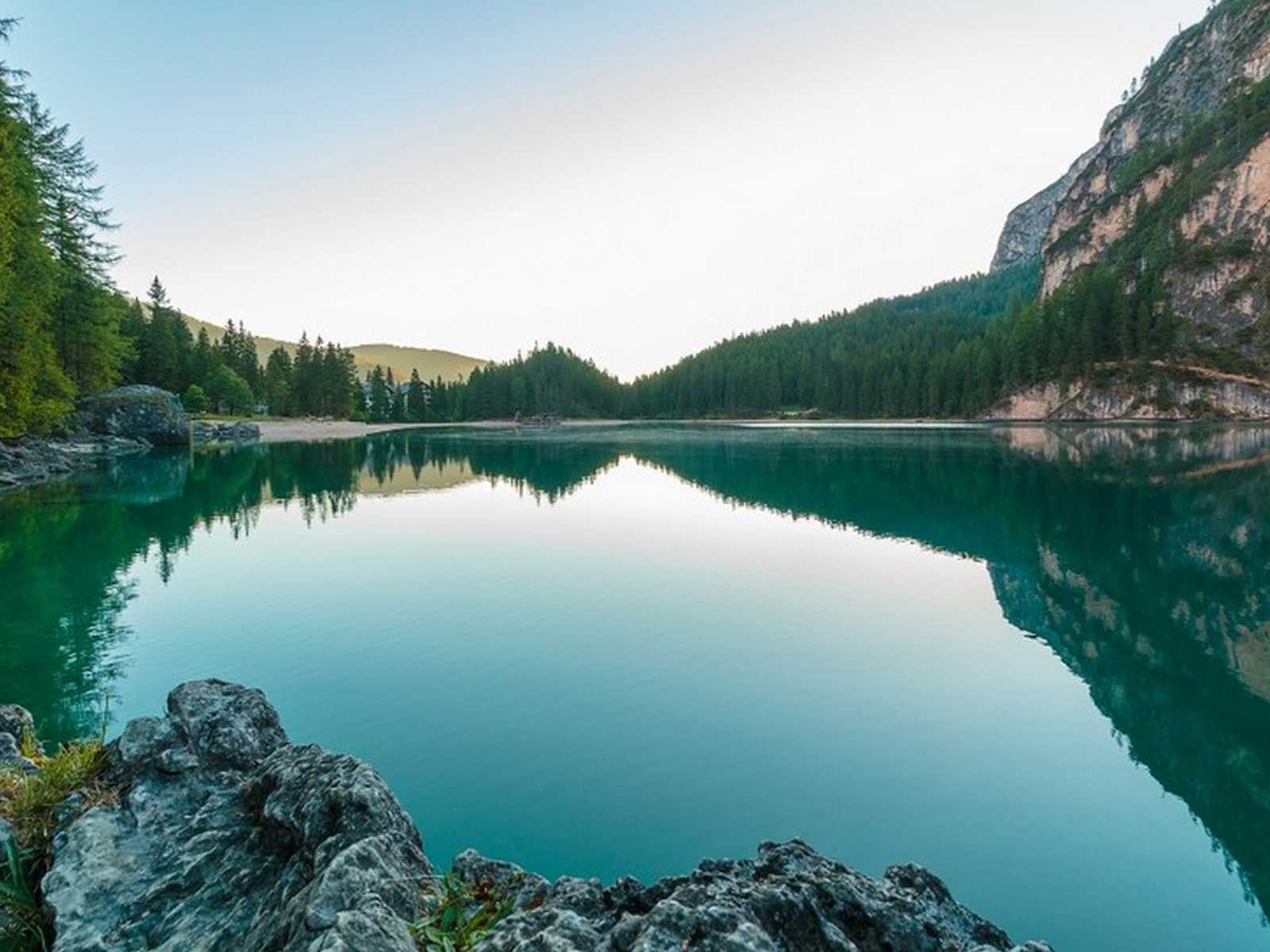 אגם הררי שקט עם מים טורקיז ונוף הרים באזור דולומיטים