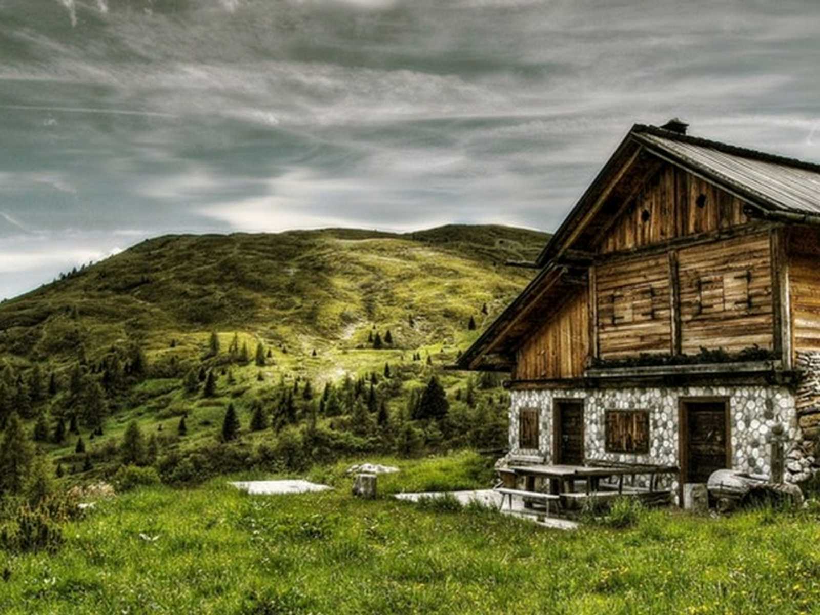 בית הררי מסורתי ונוף ירוק בהרי דולומיטים באיטליה