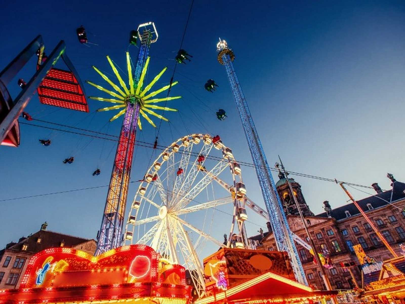 פארק שעשועים מואר בטוקיו בשעות הערב עם גלגל ענק ואווירה חגיגית