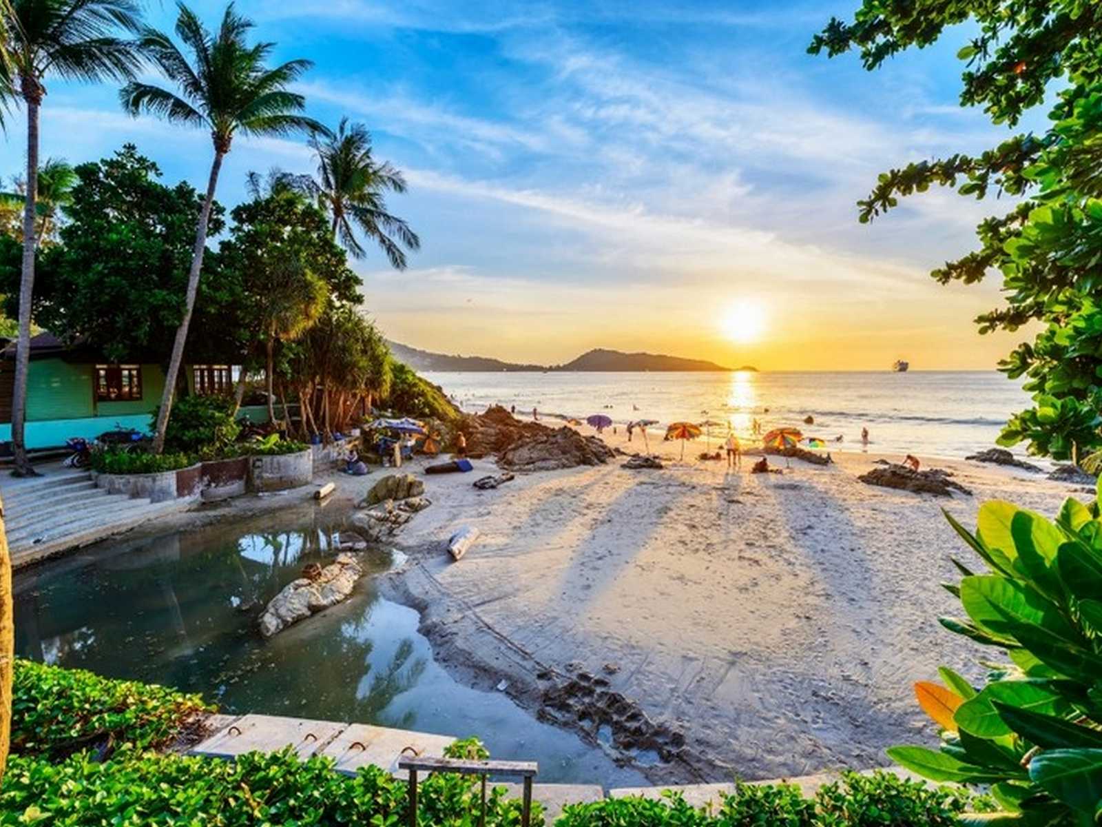 חוף טרופי יפה בשקיעה בתאילנד עם ילדים