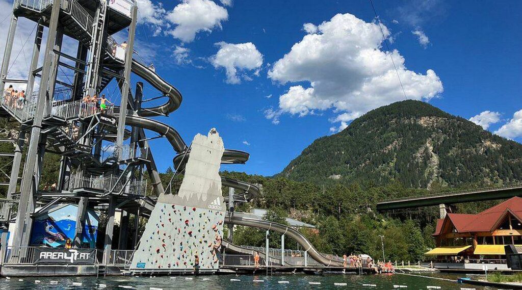 Giant water slides twisting above the lake — one of the highlights of AREA 47 adventure park.